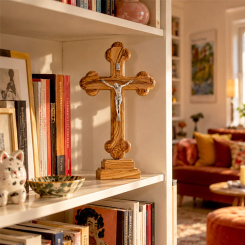 Budded olive wood standing crucifix displayed on a shelf in a home