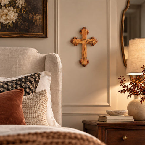 Bethlehem olive wood budded wall cross hanging on a bedroom wall