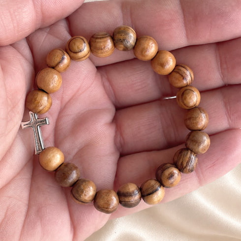 Olive wood bead bracelet with silver-tone cross shown on beads