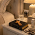 Nightstand with a Bible, comfort cross, glass of water, and other items.