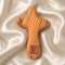 Olive wood comfort cross with the Piece of Holy Land logo on white background .