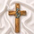 A handcrafted olive wood communion cross with a metal emblem of a praying girl on it.