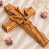 Handcrafted olive wood cross featuring an embossed dove motif, set against a white background with rose buds.