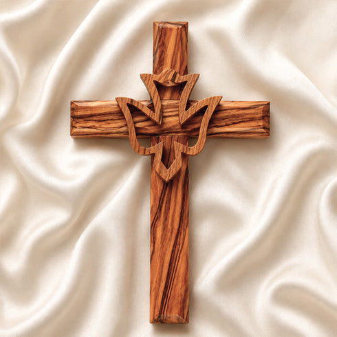 Frontal image of a handcrafted olive wood cross featuring an embossed dove motif, set against a white background.