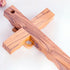 Back of a handcrafted olive wood cross featuring an embossed dove motif, set against a white background.