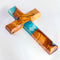 Image of a handcrafted olive wood cross with blue and green epoxy, polished and displayed on a white background.