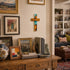 Living room with wooden console table displaying decorative items, framed pictures, and a cross on the wall.