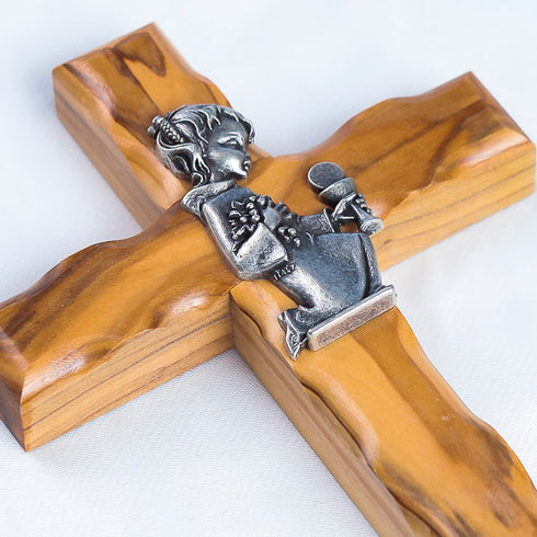 A close up on a handmade olive wood cross for Girl Communion on a white background.