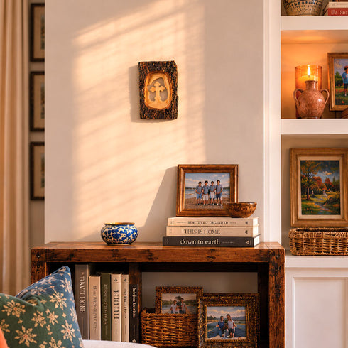Nestled corner of a room with a wooden shelf displaying books, decorative items, and framed photos.