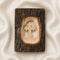 Pack shot of a standing olive wood cross handmade of natural bark, placed on a golden cloth.