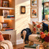 Cozy living room with a beige sofa, floral pillows, and decorative books.