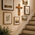 Wall with framed pictures and a wooden cross above a staircase