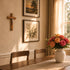 Dining room with wooden table, chairs, and a vase of flowers on a windowsill.