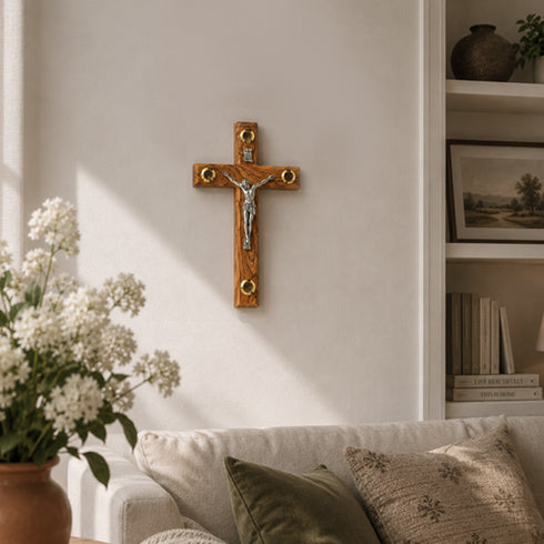 Wooden cross with Jesus Christ figure on a wall in a living room setting.