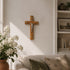 Wooden cross with Jesus Christ figure on a wall in a living room setting.