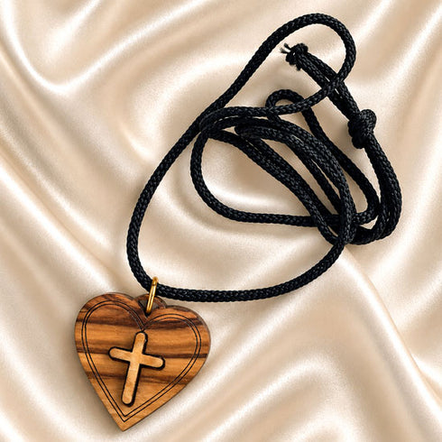 Olive wood heart cross pendant on black cord, angled view
