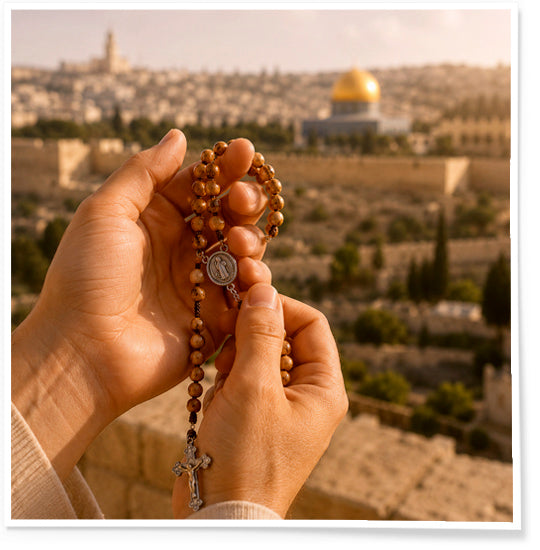 Hands holding a rosary with a scenic view of a city in the background