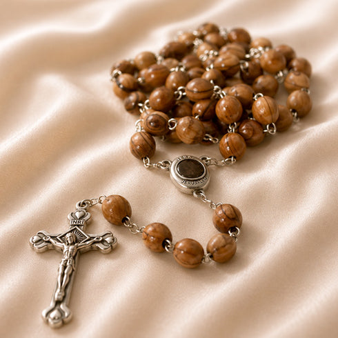 A handmade olive wood rosary with oval beads and iron crucifix, featuring a Mary and baby Jesus iron centrepiece.