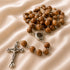 A handmade olive wood rosary with oval beads and iron crucifix, featuring a Mary and baby Jesus iron centrepiece.