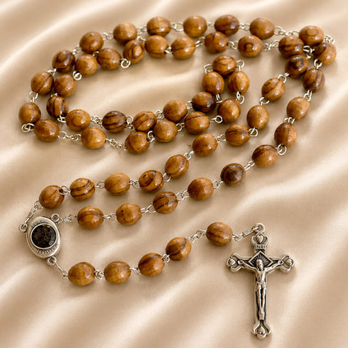 A handmade olive wood rosary with a cross and holy soil contained in a special compartment.