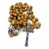 A handmade olive wood rosary with a cross and holy soil contained in a special compartment.