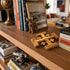 Wooden shelf with decorative items including books, a cross, a camera, and a small statue.