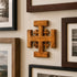 Wooden cross wall art with framed photographs on a wall
