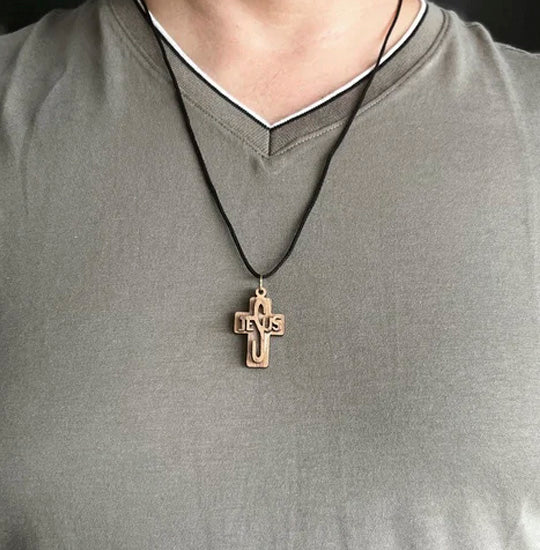Man wearing a gray shirt with a cross pendant necklace.