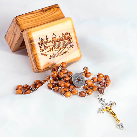 Image of an olive wood box with Jerusalem engraved on it and a handmade olive wood rosary with Holy Soil centrepiece next to the box.