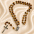 5-decade wood rosary with Holy Water centerpiece on a creamy color cloth.