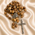 Olive wood rosary with Holy Water centerpiece and apostile cross on a creamy color cloth.