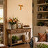 Living room with wooden console table, floral arrangement, and decorative items.