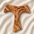 Frontal image of a handmade olive wood tau cross, also known as Saint Anthony's Cross, with modern crucifix design displayed on a white background with petals.
