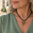 Tau crucifix pendant necklace on black cord worn at the neckline