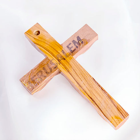 Image showing the back of an handcrafted olive wood thorn cross with a crucifix, placed on a white surface.