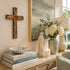Decorative setting with books, statue, candle, and flowers on a console table.