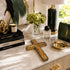 Decorative items on a marble surface including books, a cross, and a handbag.