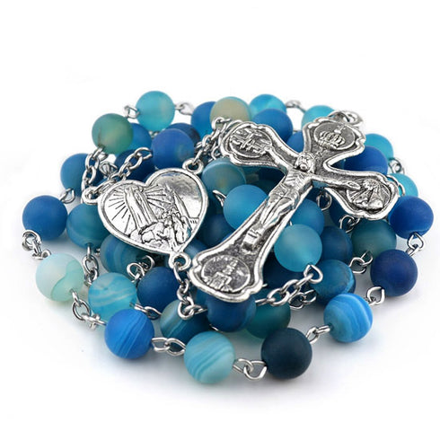 Blue rosary with silver cross and heart-shaped medal on a white background
