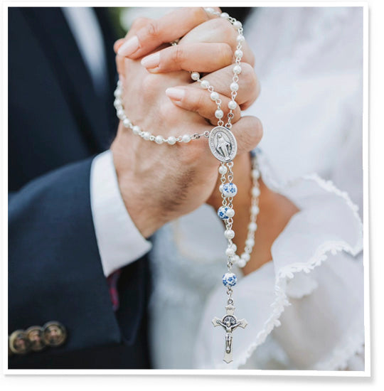 Two people holding hands with a rosary, symbolizing unity and faith.