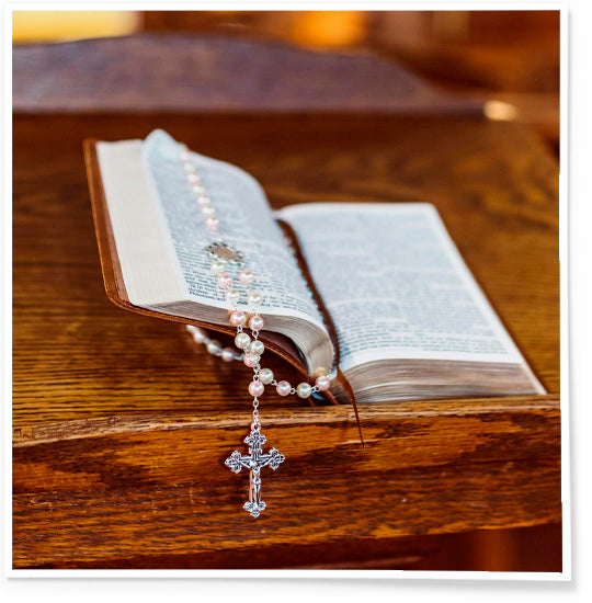 Open Bible with a rosary on a wooden surface