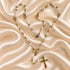 Detailed view of a white pearl Catholic rosary with gold-tone metalwork and crucifix