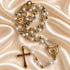 Close view of white pearl rosary beads, gold-tone links and crucifix details