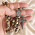 St. Benedict rosary in hand with round picture medal and silver-tone cross on jasper beads