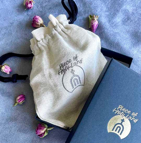 Piece of Holy Land cotton branded bag and box on blue background