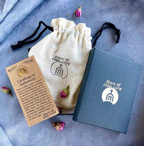 Piece of Holy Land branded cotton bag, blue branded box and a certificate of authenticity on a blue background.