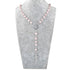 Pink beaded rosary necklace on a gray bust