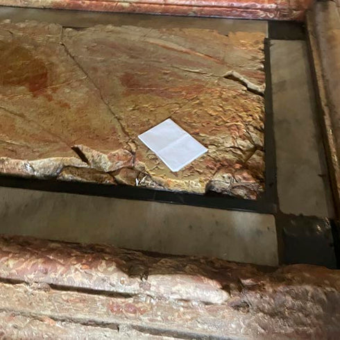 Prayer request note reverently placed on the Stone of Anointing inside the Church of the Holy Sepulchre.