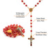 Red glass bead rosary with gold accents and St Benedict crucifix on a white background.