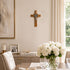 Dining room with a cross on the wall, framed picture, and white flowers in a vase.