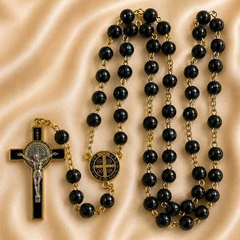 Black and gold Catholic rosary with a black and gold crucifix, and a round Saint Benedict medallion.
